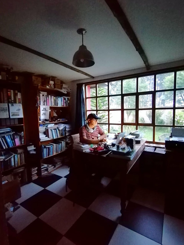 Writer in his study, surrounded by many books