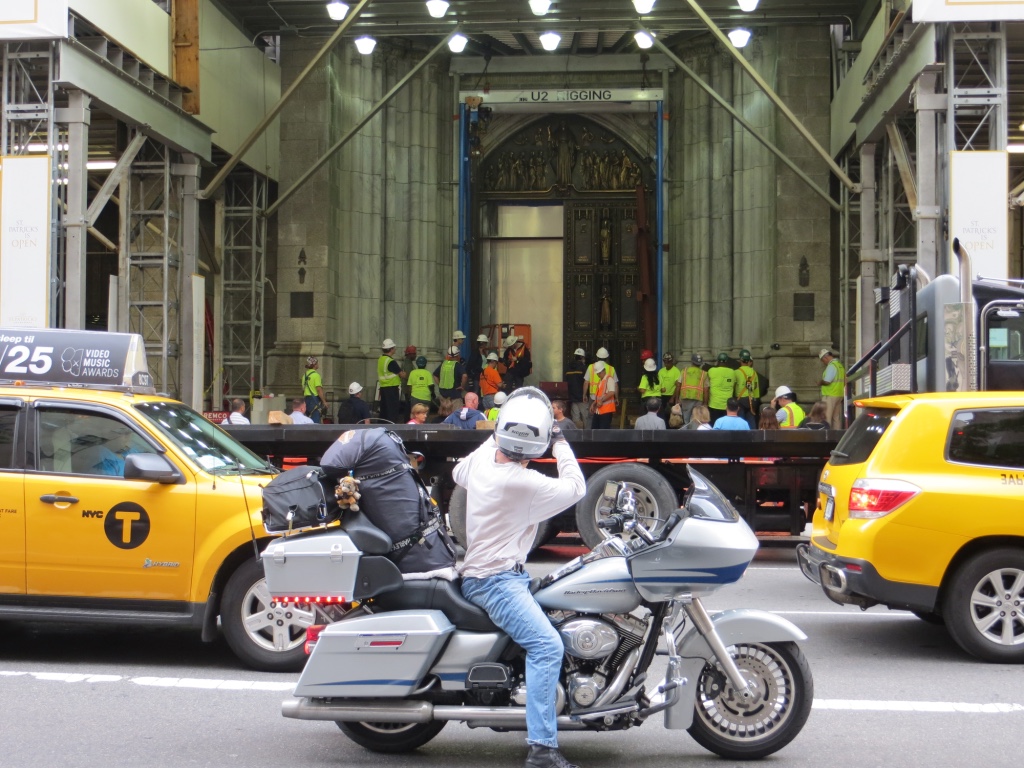 Picture of a guy on a motorbike taking a picture of St.Patricks cathedral on Manhattan ,New York.