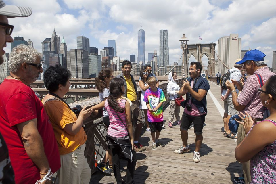 Tour group + guide on the Brooklyn Bridge, Manhattan, New York. 