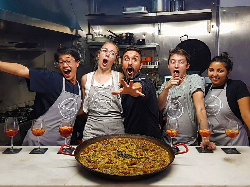 Participants & the master learning how to make paella during a cooking class in Valencia, Spain.