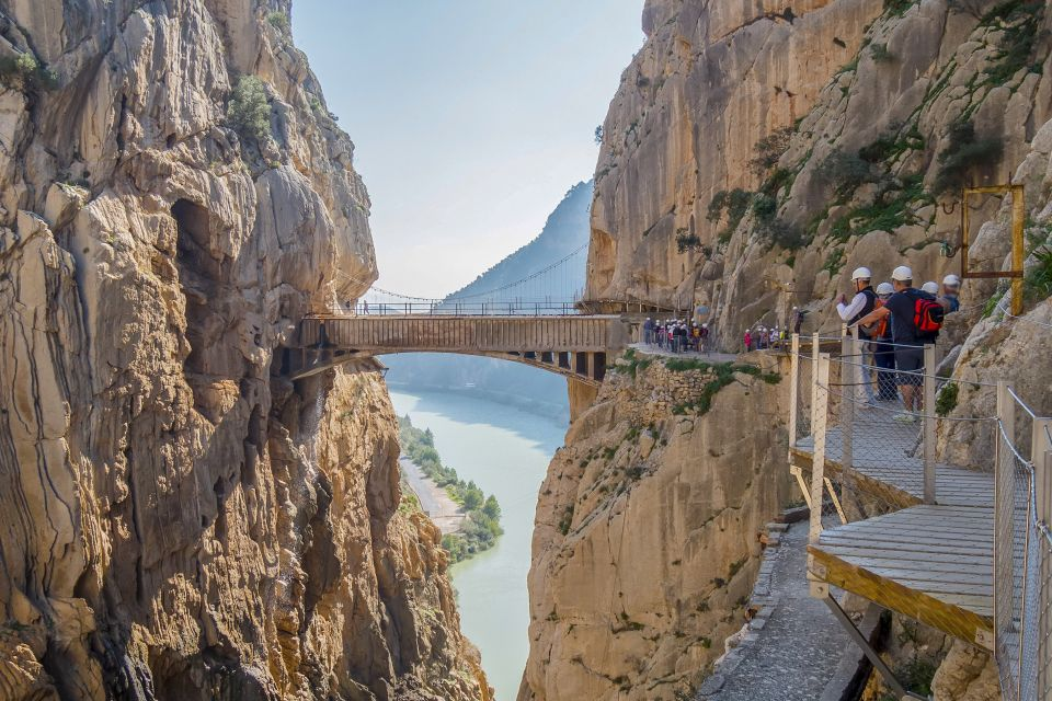 Impression of a hike along the Caminito del Rey, near Seville. Narrow trails along the mountainside, with a suspension bridge in the background.