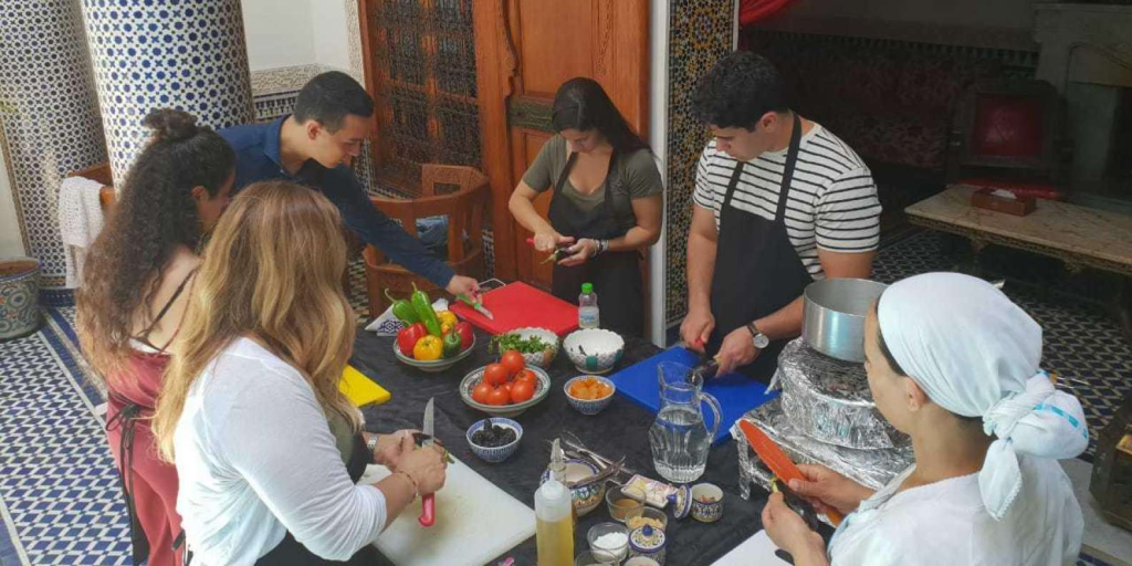 Participants preparing food at the Moroccan Cooking class during their visit to Chefchaouen. 