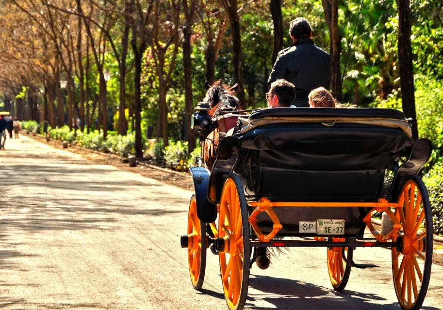A horse drawn carriage taking people through the city of Seville.