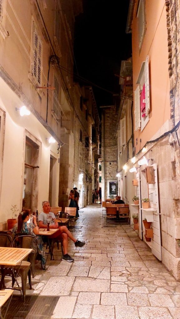 View of one of the maze-like streets of Split's city center at night. 