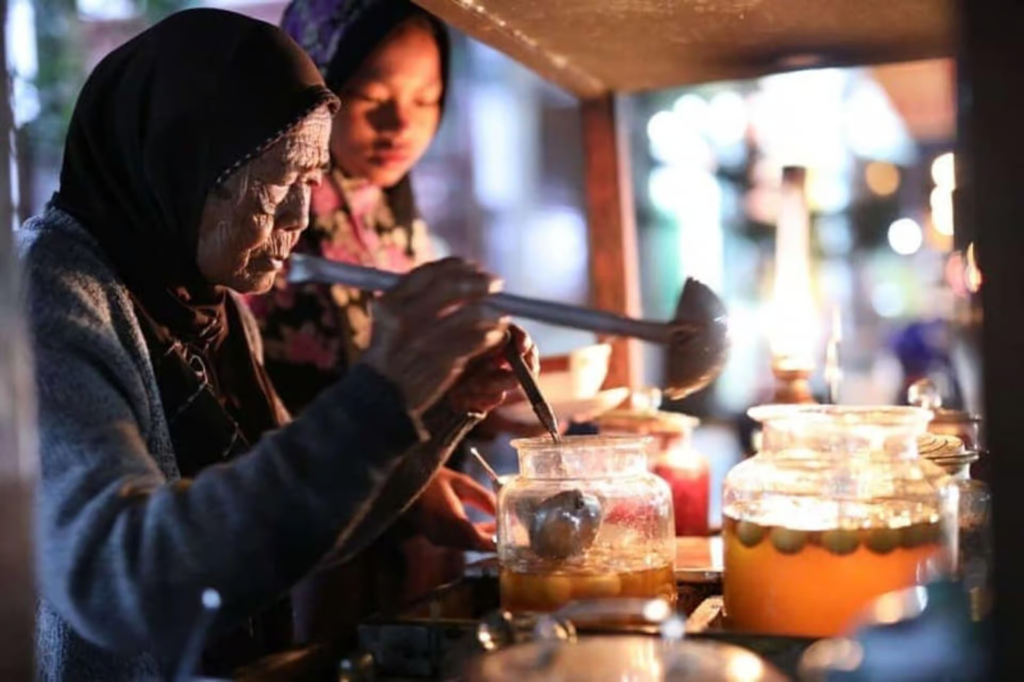 Old lady in Yogyakarta preparing drinks at the market