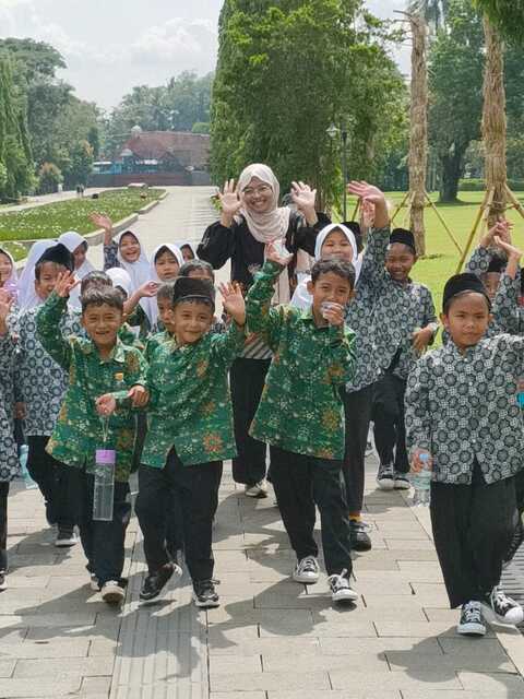 School class young studehts and teacher visiting Borobudur, waving their welcome to us.